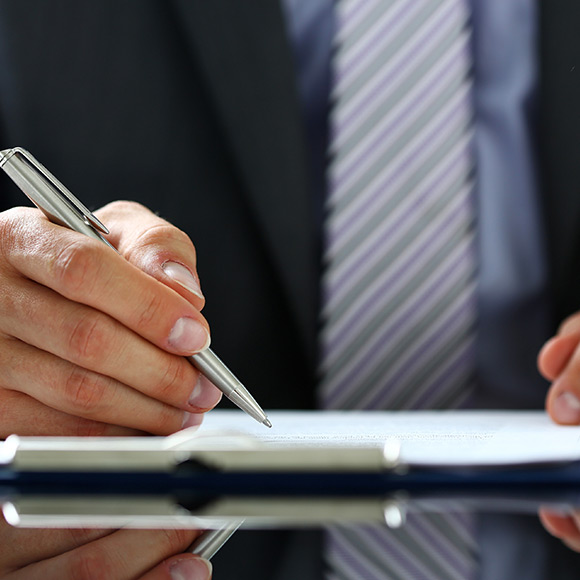 man holding pen signing document