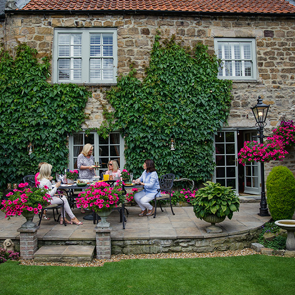 Women having garden party outside a village house